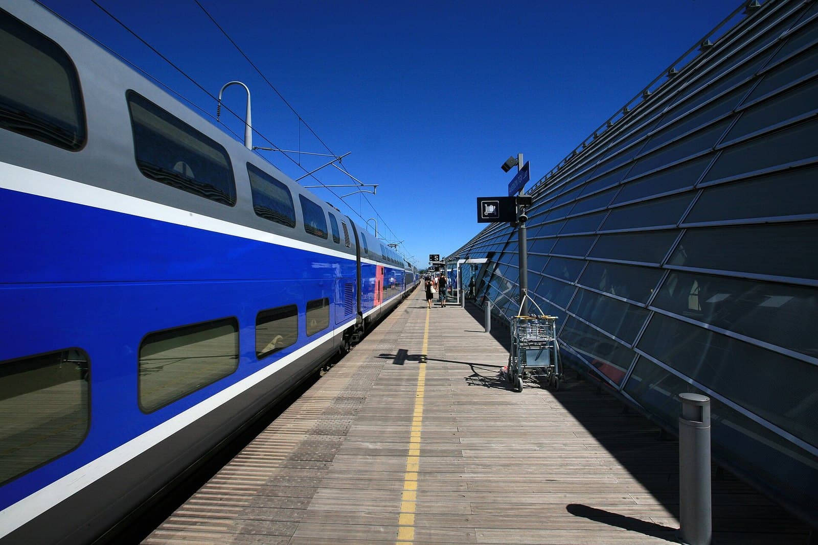 Un TGV à quai le long d'une gare, sous un ciel bleu